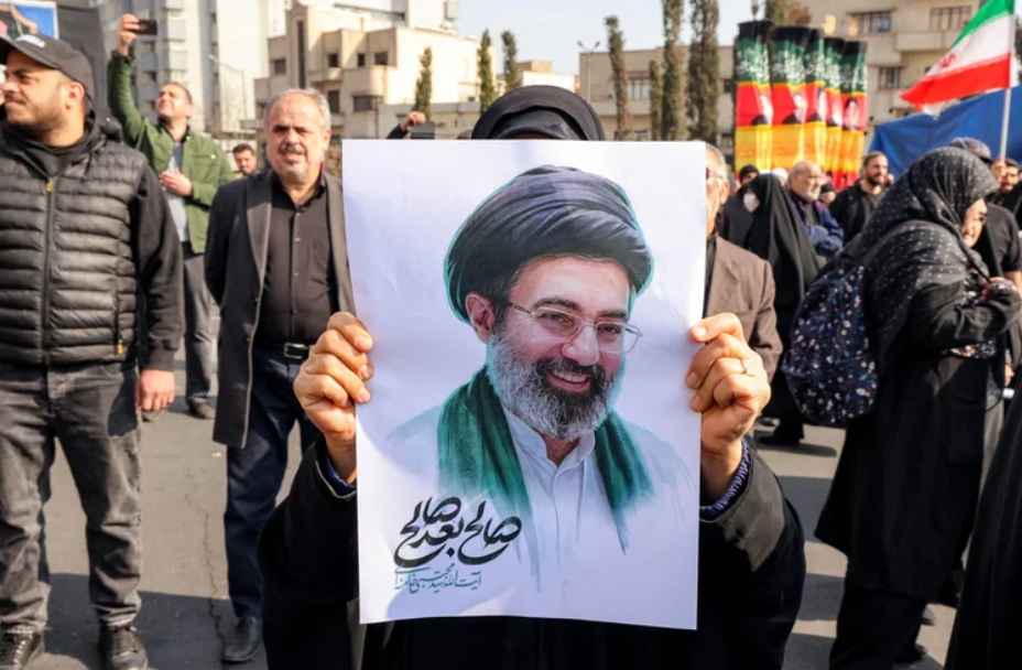 Mulher segura uma imagem do aiatol&aacute; durante ato de apoio ao novo l&iacute;der supremo do Ir&atilde; no Teer&atilde; (capital) em 09/03/26. / Foto: Atta Kenare