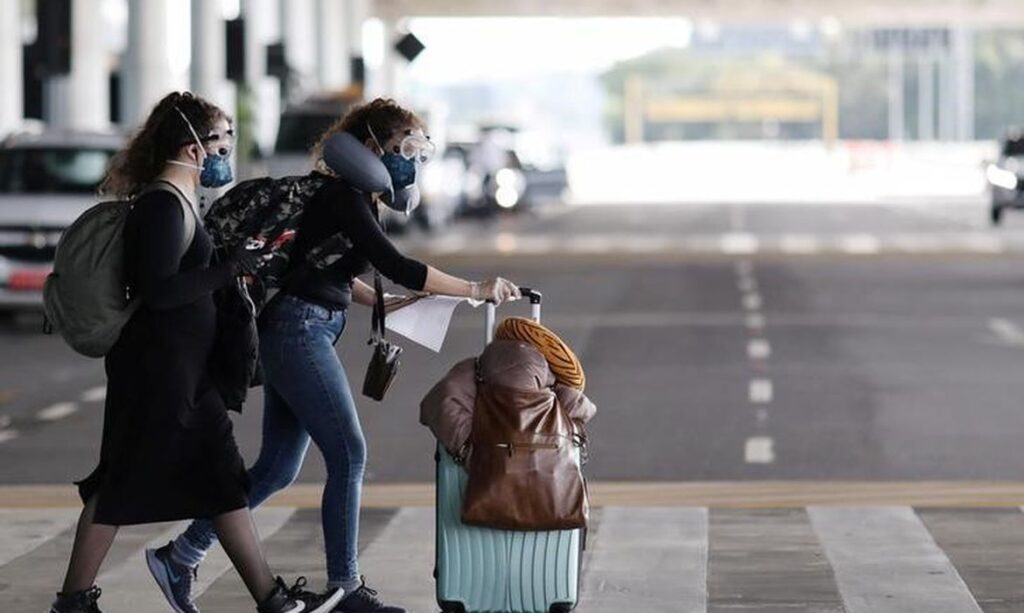 Passageiras com máscara de proteção chegam ao aeroporto de Guarulhos, em São Paulo © REUTERS/Roosevelt Cassio/Direitos reservados