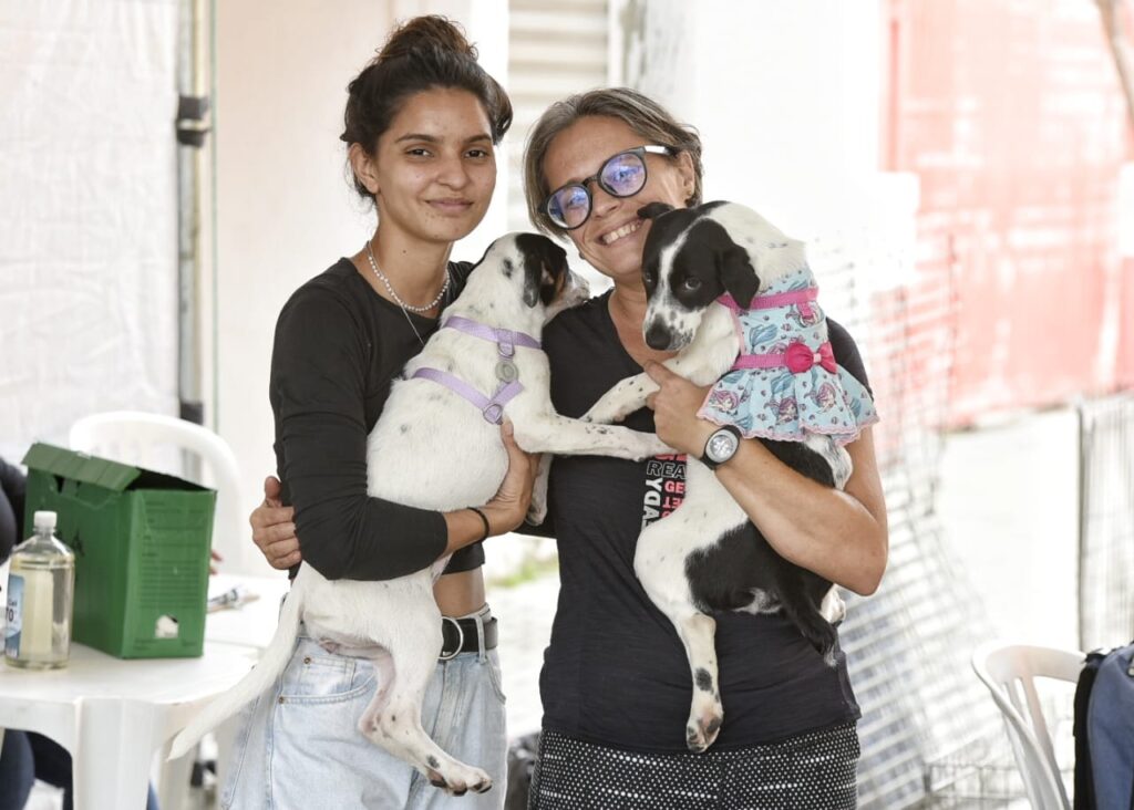 adoção de cães: duas mulheres segurando cachorros no colo